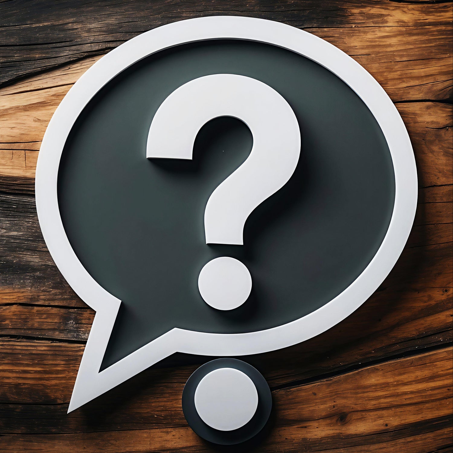 Large question mark symbol inside a speech bubble on a wooden surface