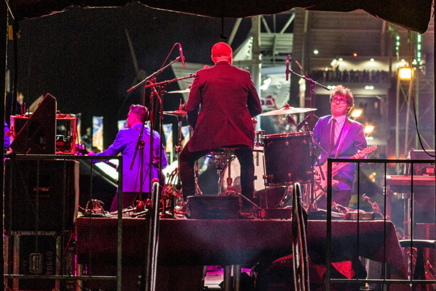 Band performing on stage with purple and red lighting